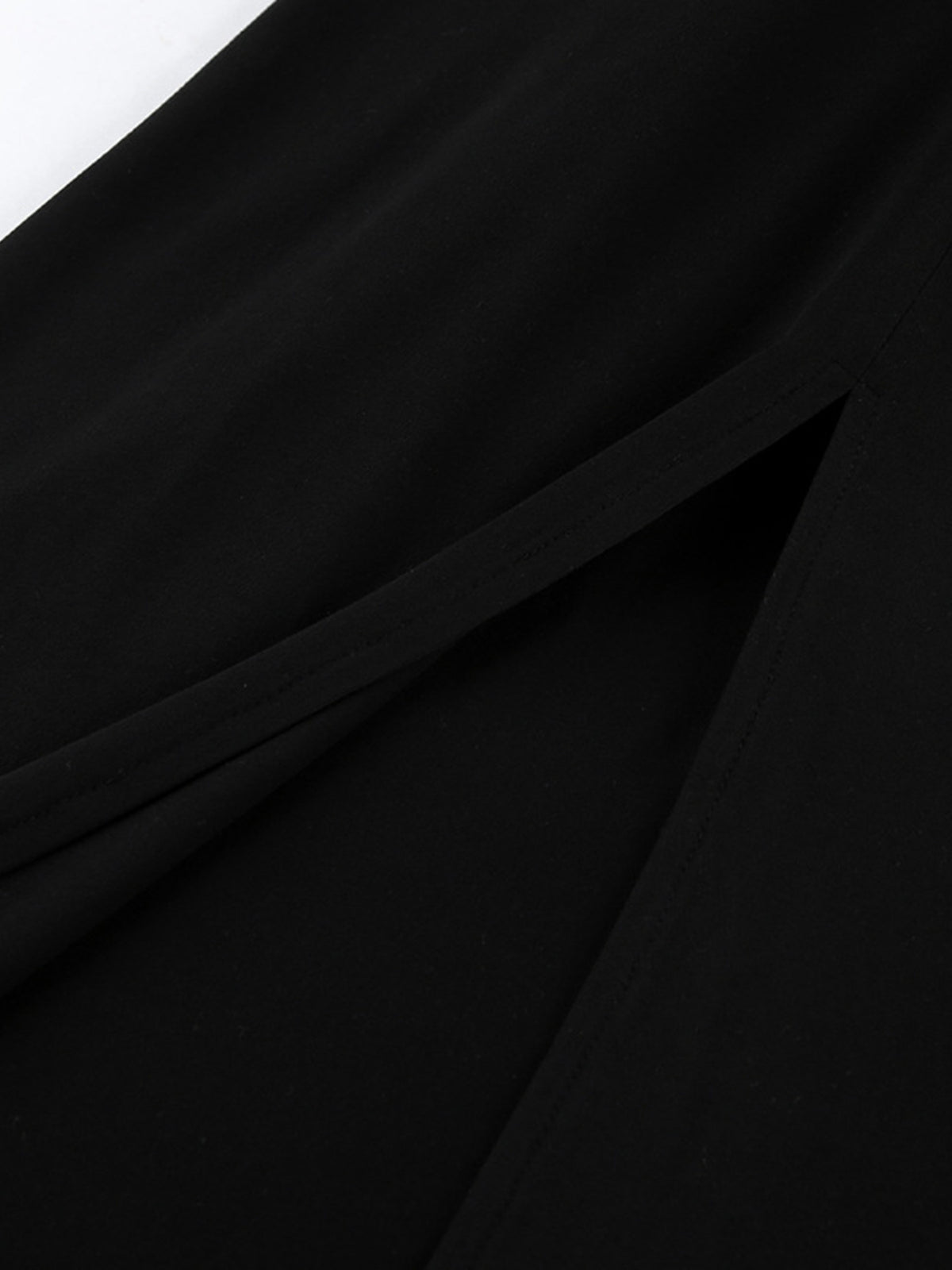 Close-up of thigh slit seam on black bodycon maxi dress