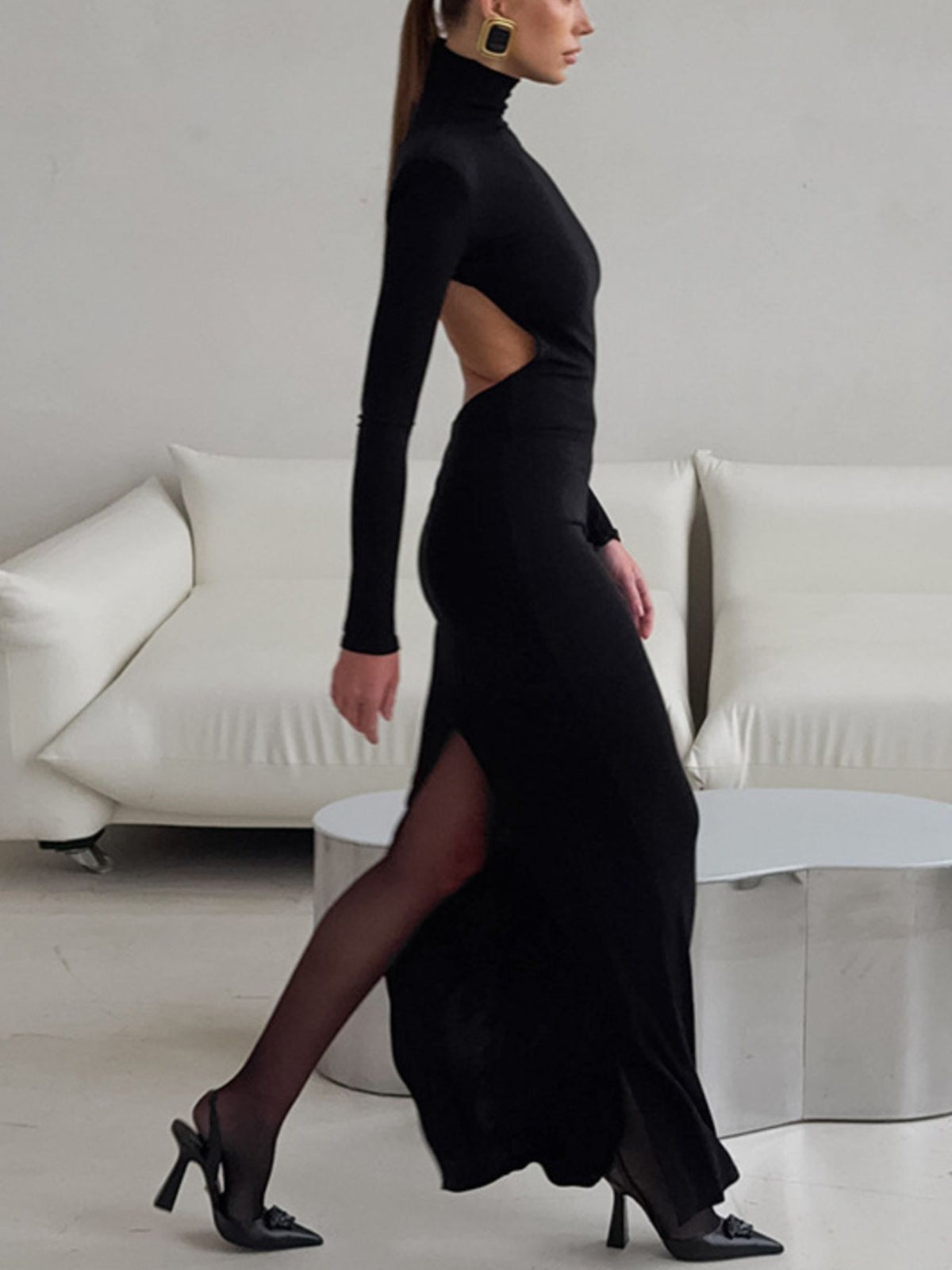 Side view of black bodycon maxi dress with open back cutout and thigh slit