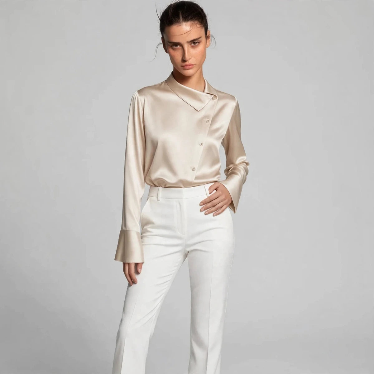 Model wearing beige satin collar blouse with white trousers in a fashion editorial