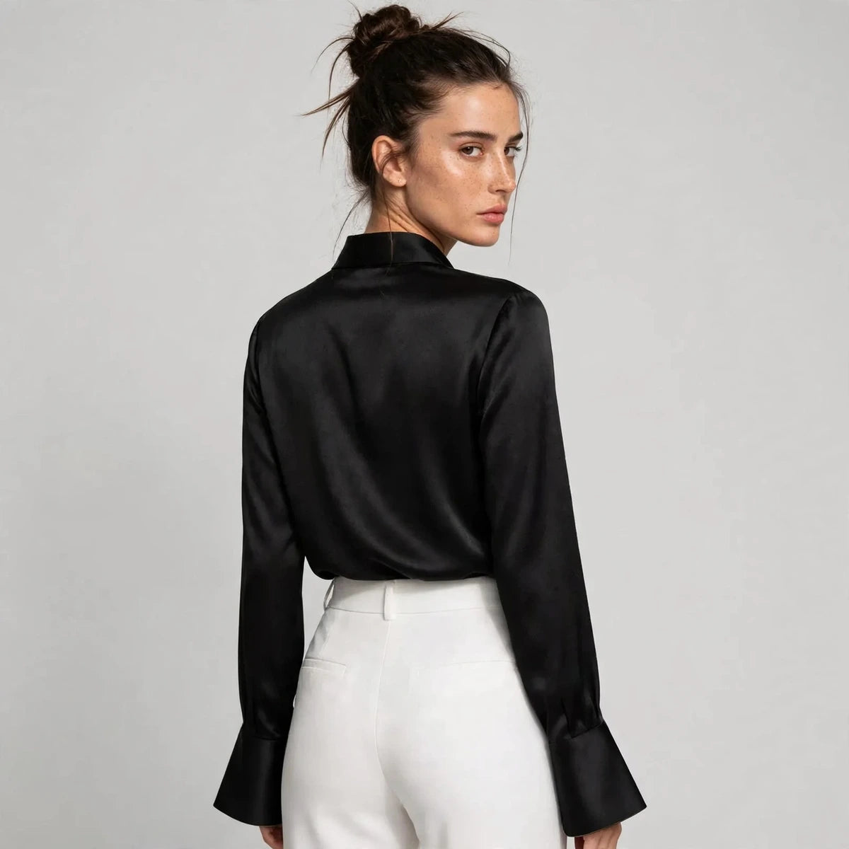 Back view of black satin collar blouse with flared sleeves
