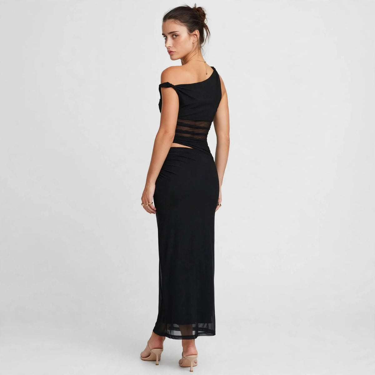 Back view of black asymmetrical cutout maxi dress