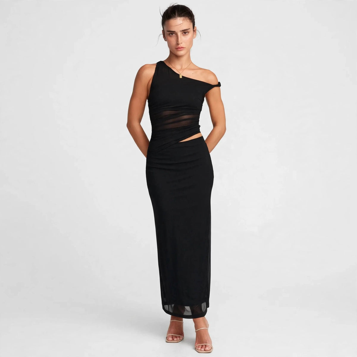 Woman wearing black asymmetrical cutout maxi dress, front view