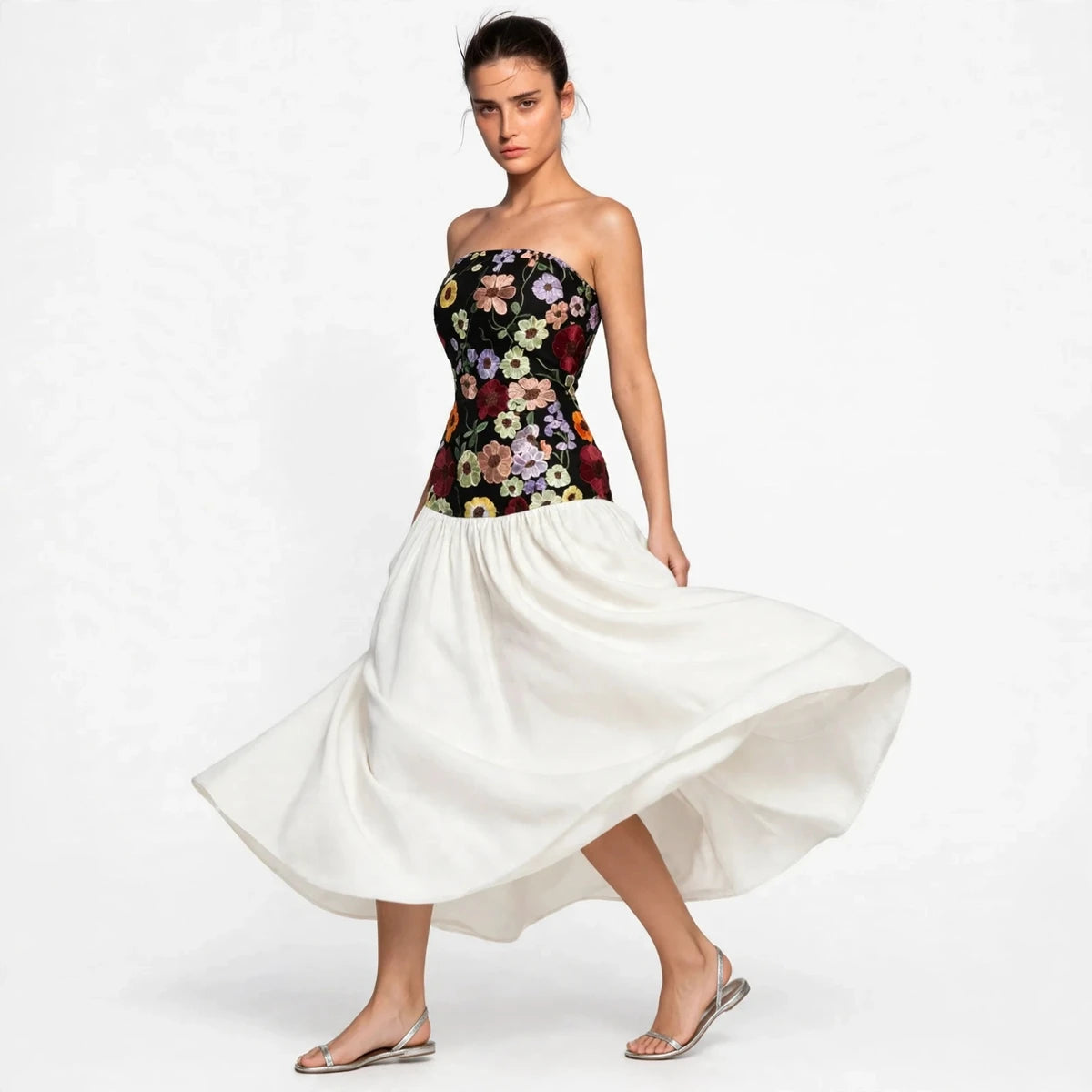 Model wearing black floral embroidered tube maxi dress with twirling white skirt