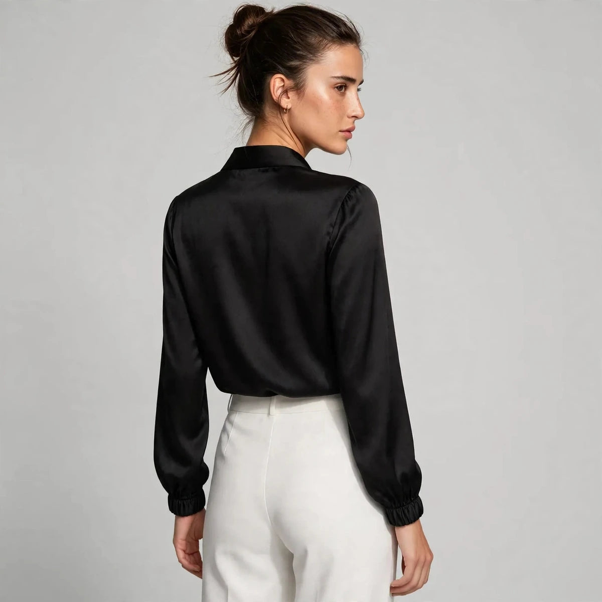 Back view of black satin tie-neck blouse with shawl collar