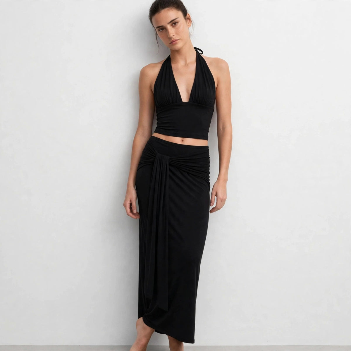 Front torso view of black halter crop top and draped maxi skirt