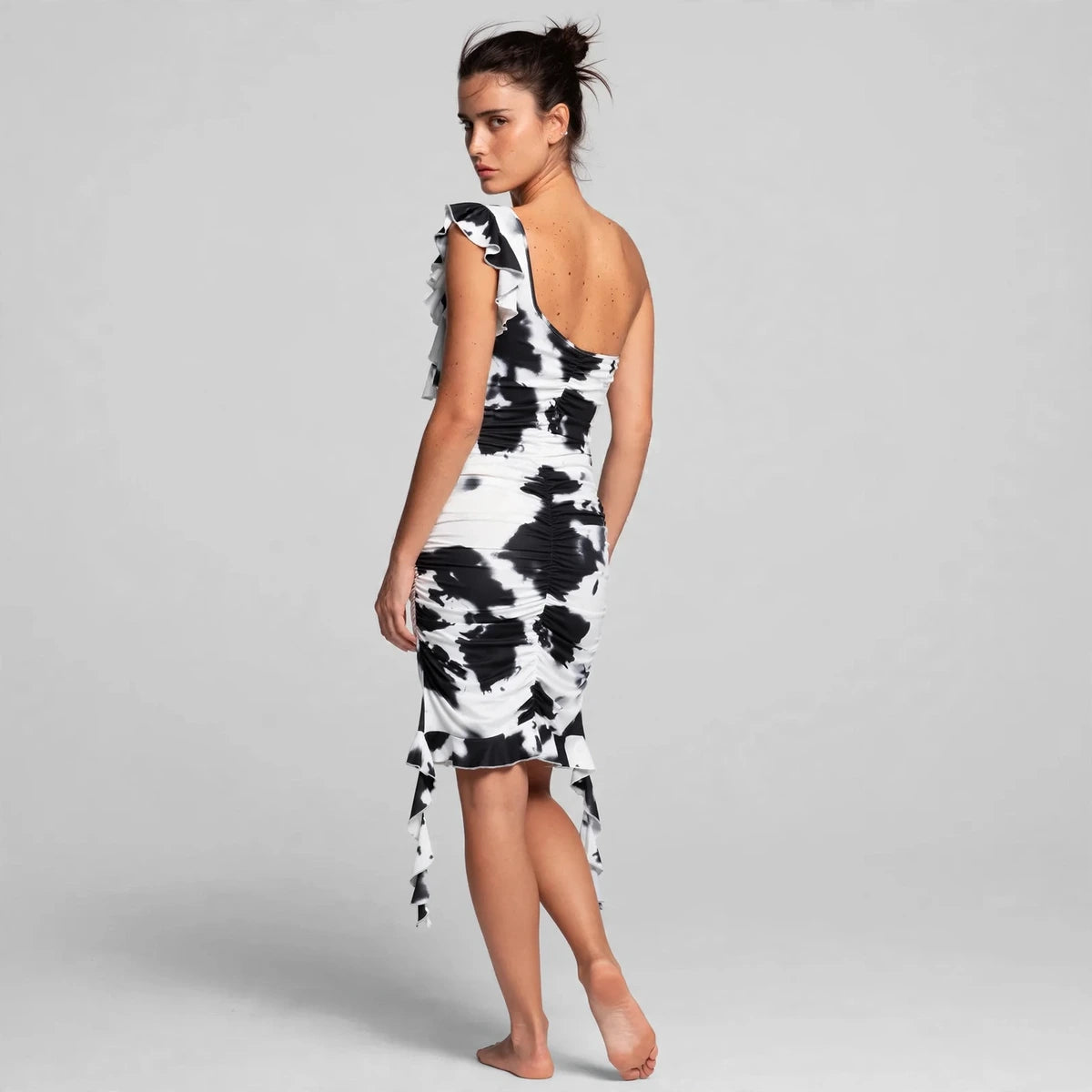 Back view of black tie-dye ruffled one-shoulder mini dress
