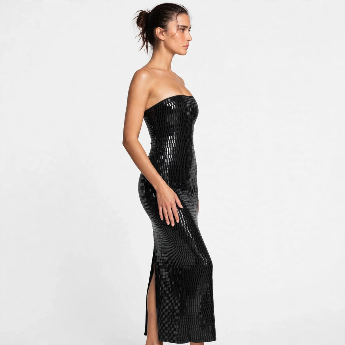 Side view of black sequin strapless tube maxi dress showing back slit