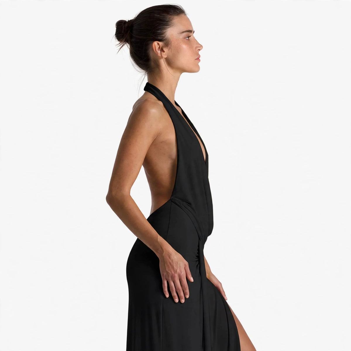 Side view of black backless halter maxi dress showing open back and thigh slit