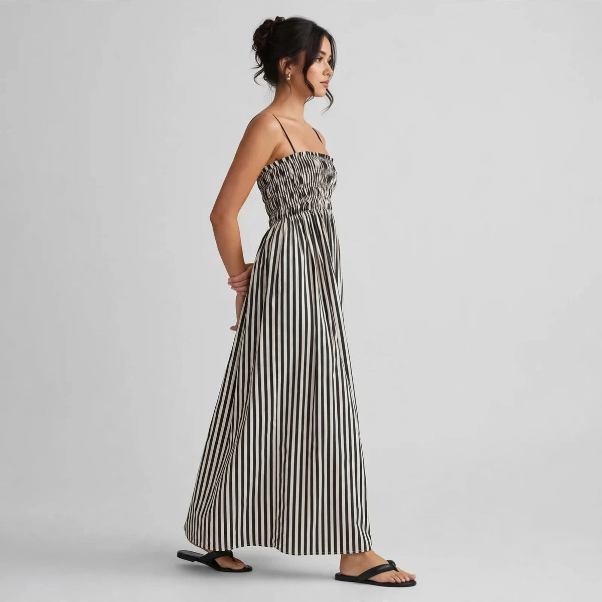 Side view of black and white striped smocked cami maxi dress with smocked bodice