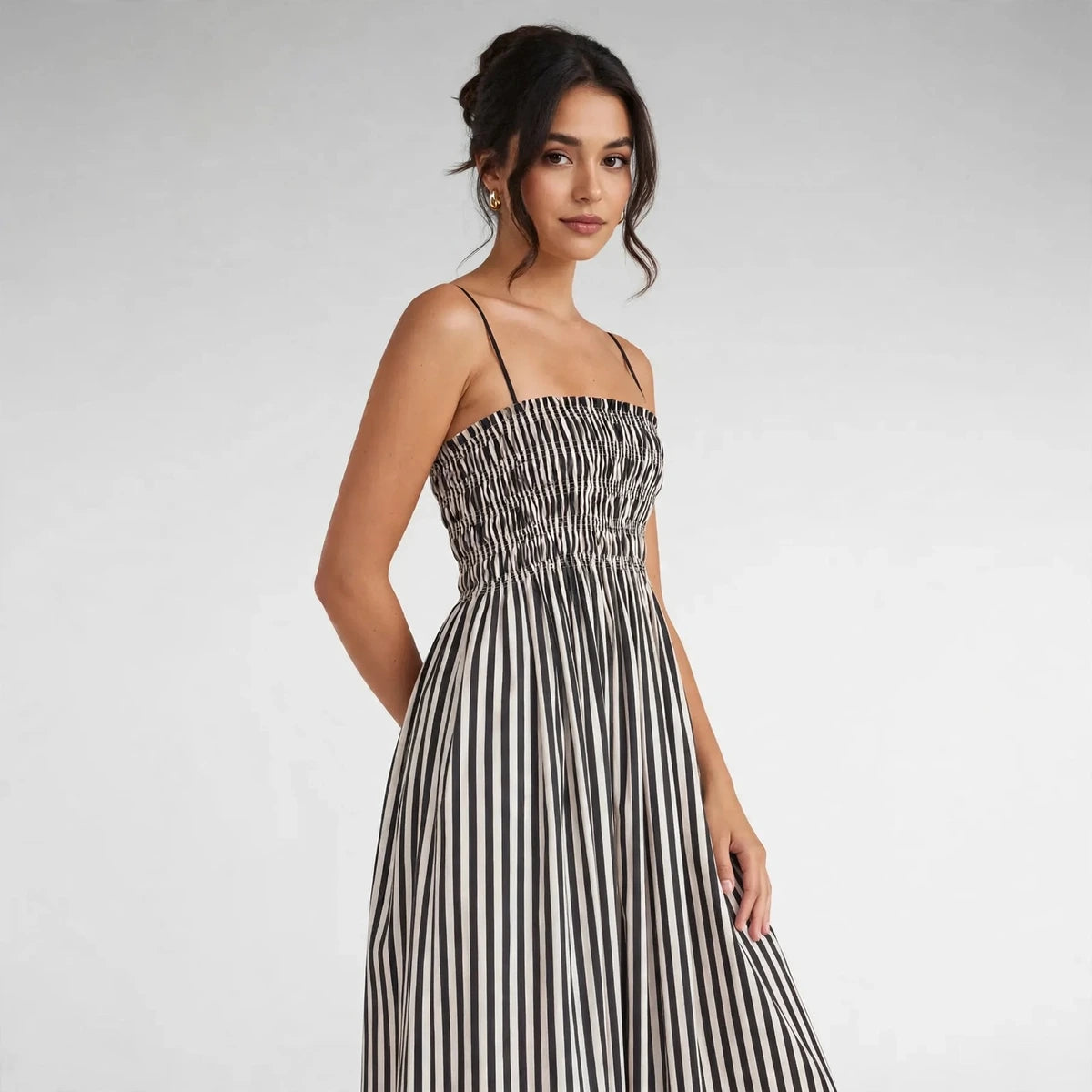 Woman wearing black and white striped smocked cami maxi dress, front view