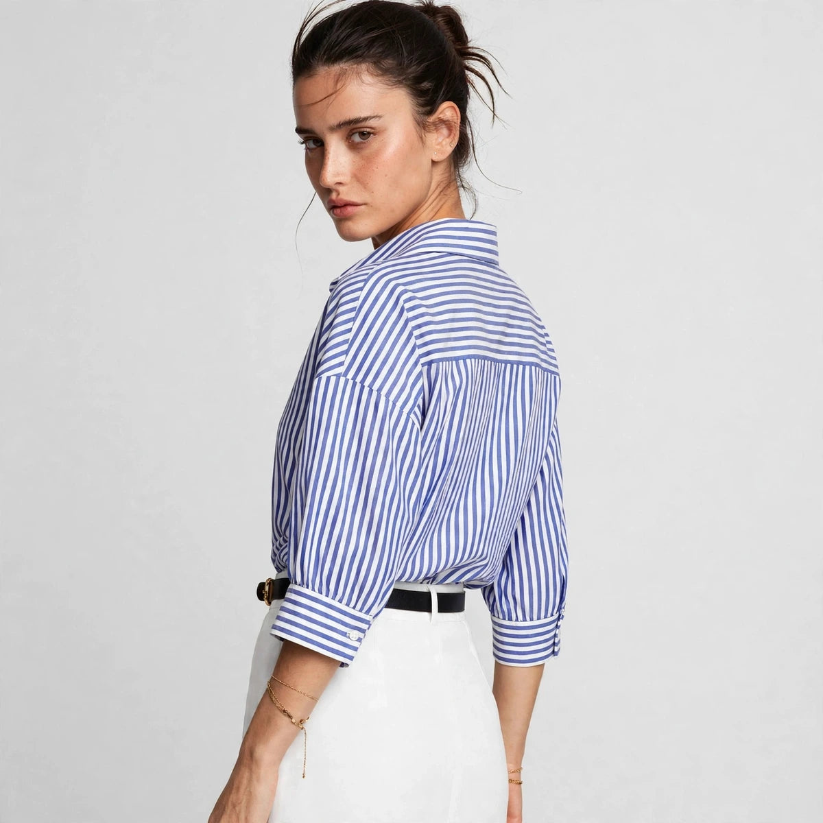 Back view of blue and white striped button-down shirt with rolled sleeves