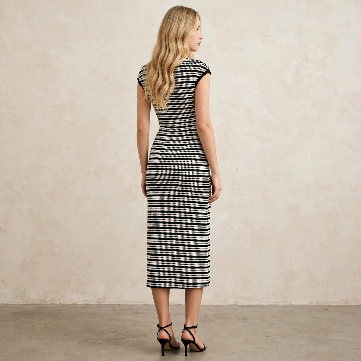 Women's black and white striped bodycon midi dress, back view