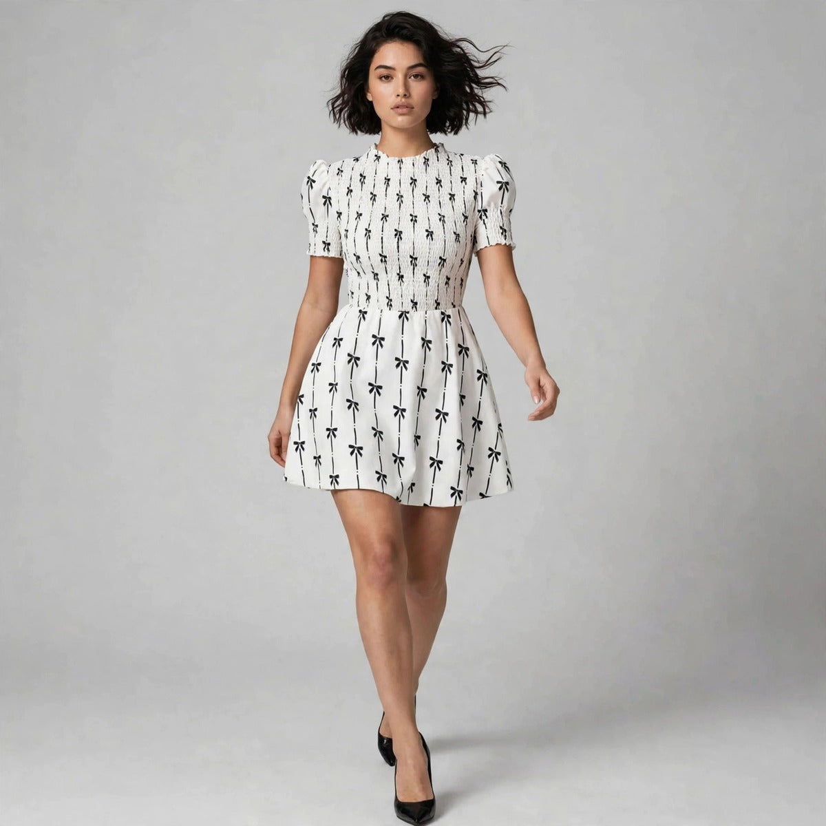 Model walking in white bow print mini dress with puff sleeves