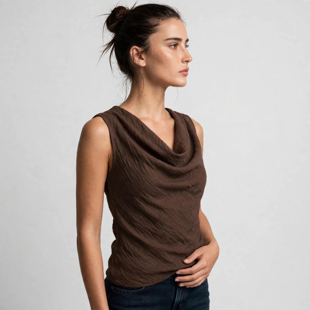 Side view of a brown cowl neck tank top showing the draped sleeveless silhouette