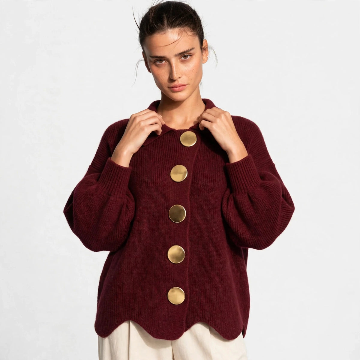 Woman wearing burgundy gold-button knit cardigan with lantern sleeves, front view