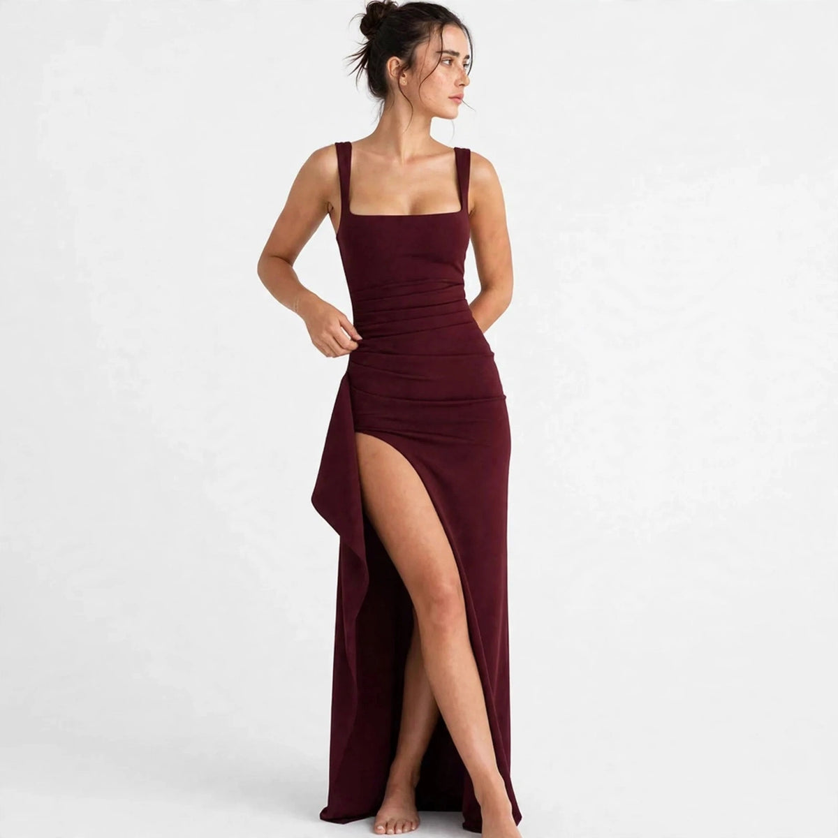 Woman wearing a burgundy ruched high-slit maxi dress with square neckline, front view