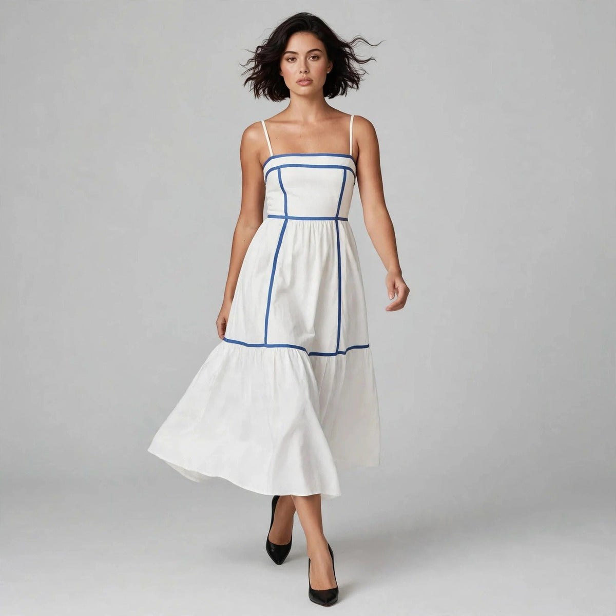 Model walking in white cami midi dress with blue trim