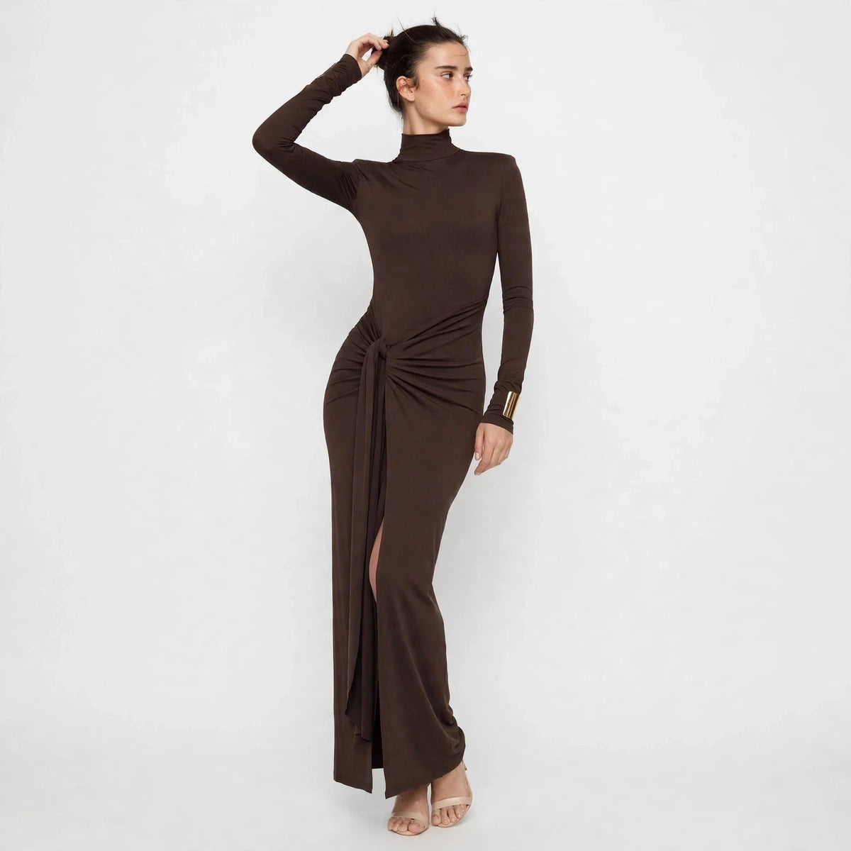 Side view of brown turtleneck maxi dress with tie waist and side slit
