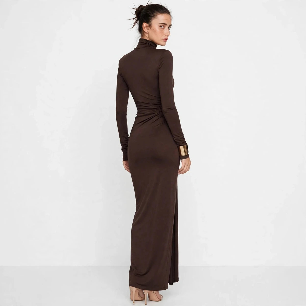 Three-quarter back view of brown turtleneck maxi dress showing the side slit