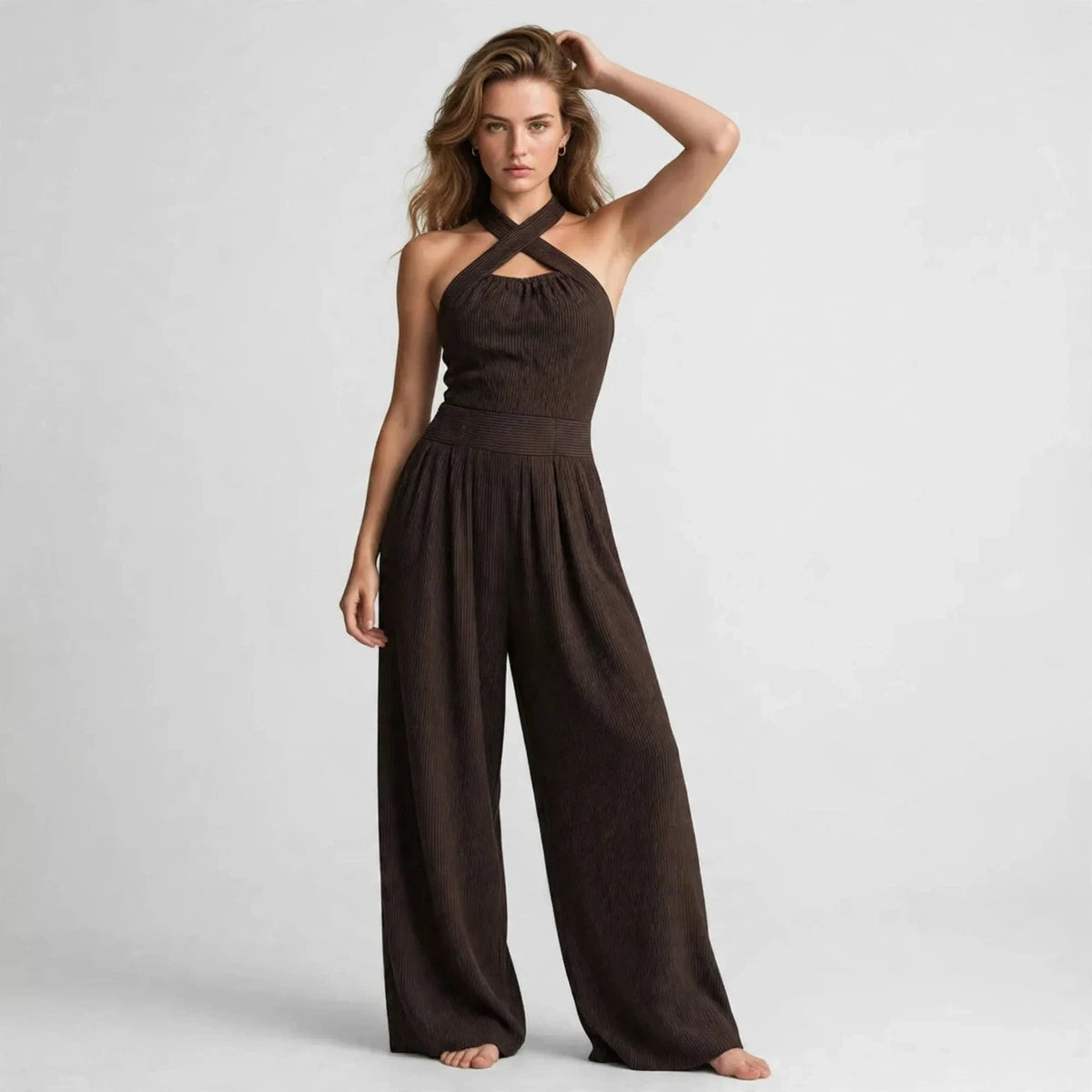 Model wearing a dark brown crisscross halter jumpsuit in a fashion editorial