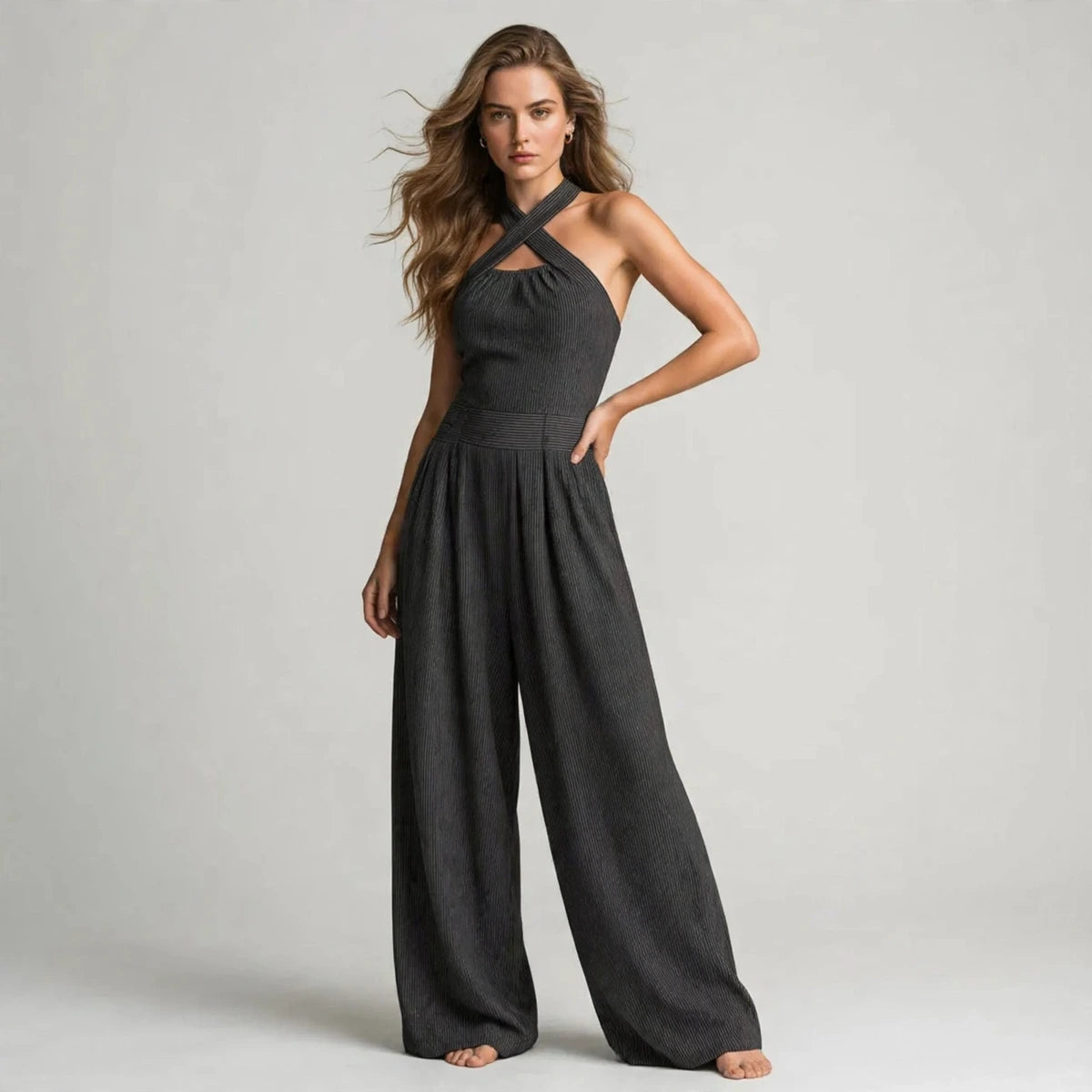 Woman wearing a dark gray crisscross halter jumpsuit with a ribbed bodice, front view