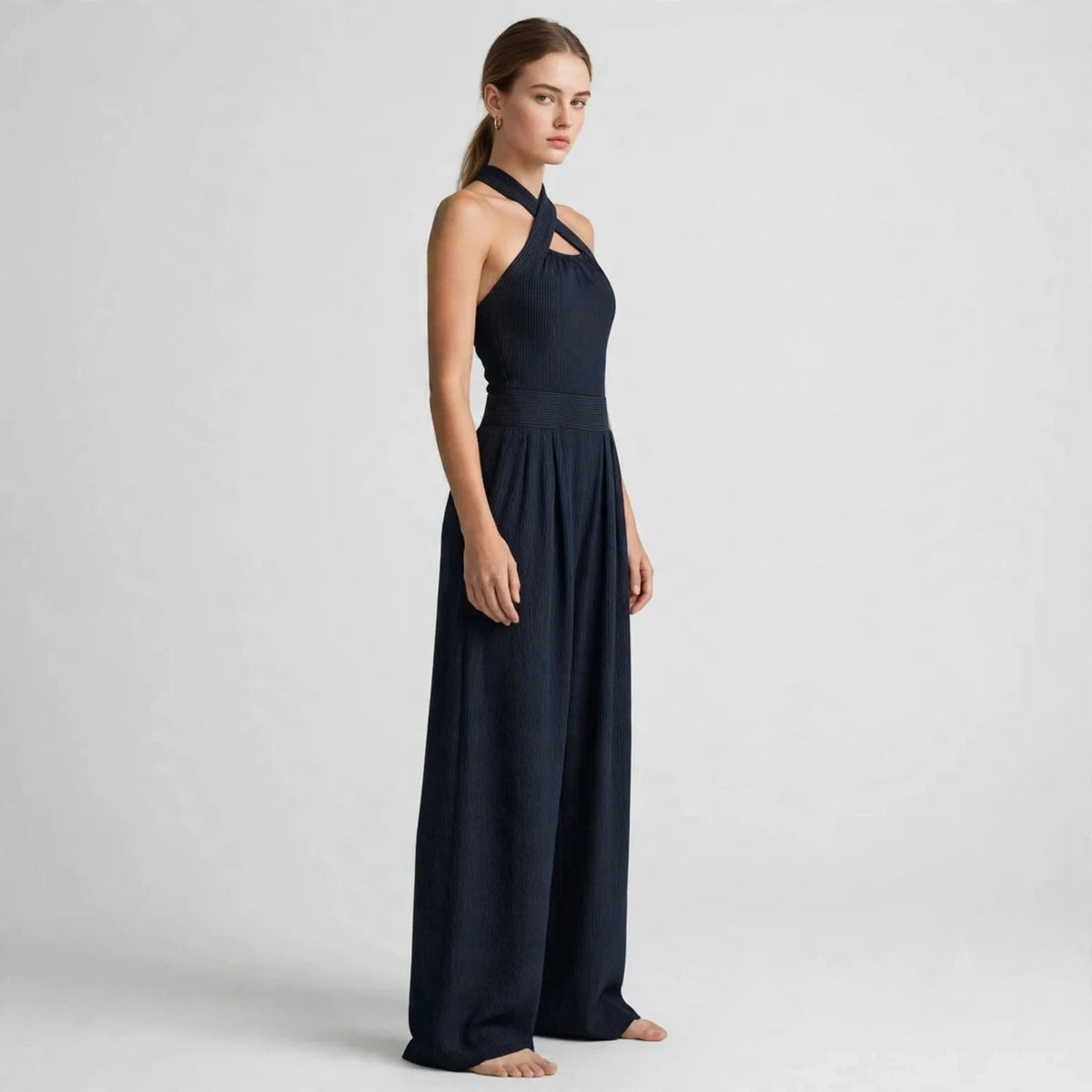 Side view of a dark navy crisscross halter jumpsuit with wide-leg pants