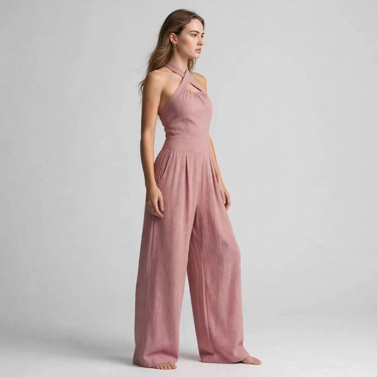 Side view of a dusty pink crisscross halter jumpsuit showing the wide-leg silhouette