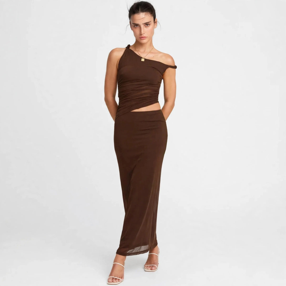 Woman wearing dark brown asymmetrical cutout maxi dress, front view