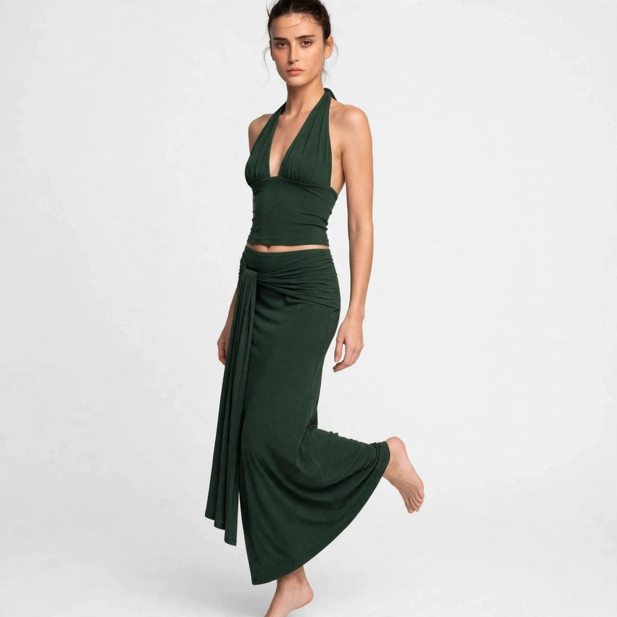 Dark green halter skirt set with flowing drape skirt in motion