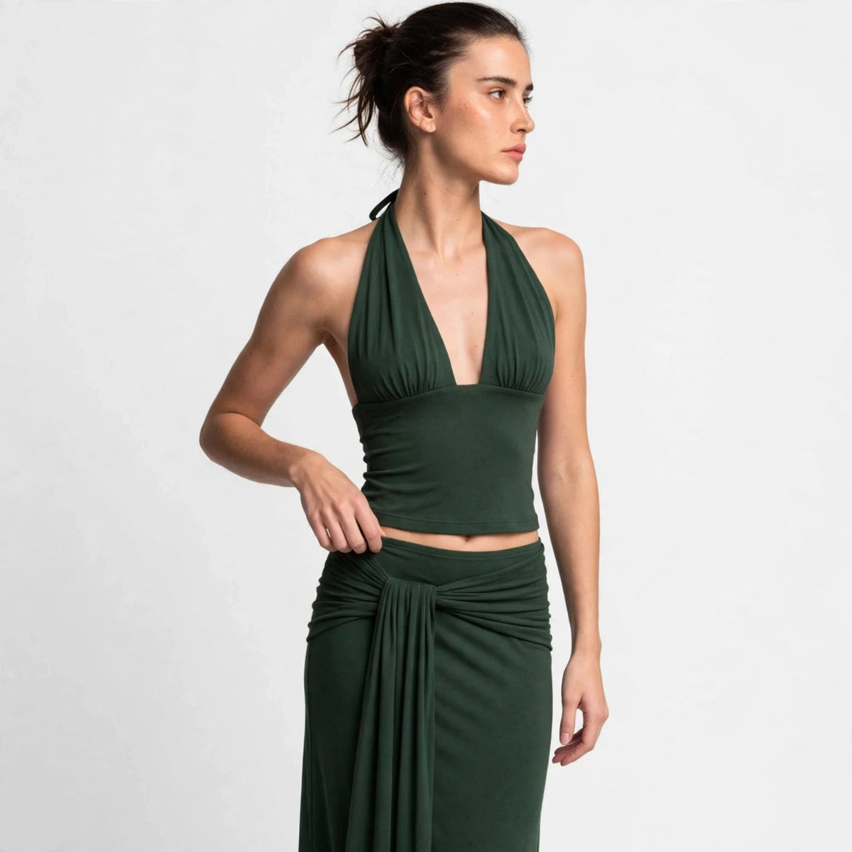 Woman wearing dark green halter top and draped maxi skirt set