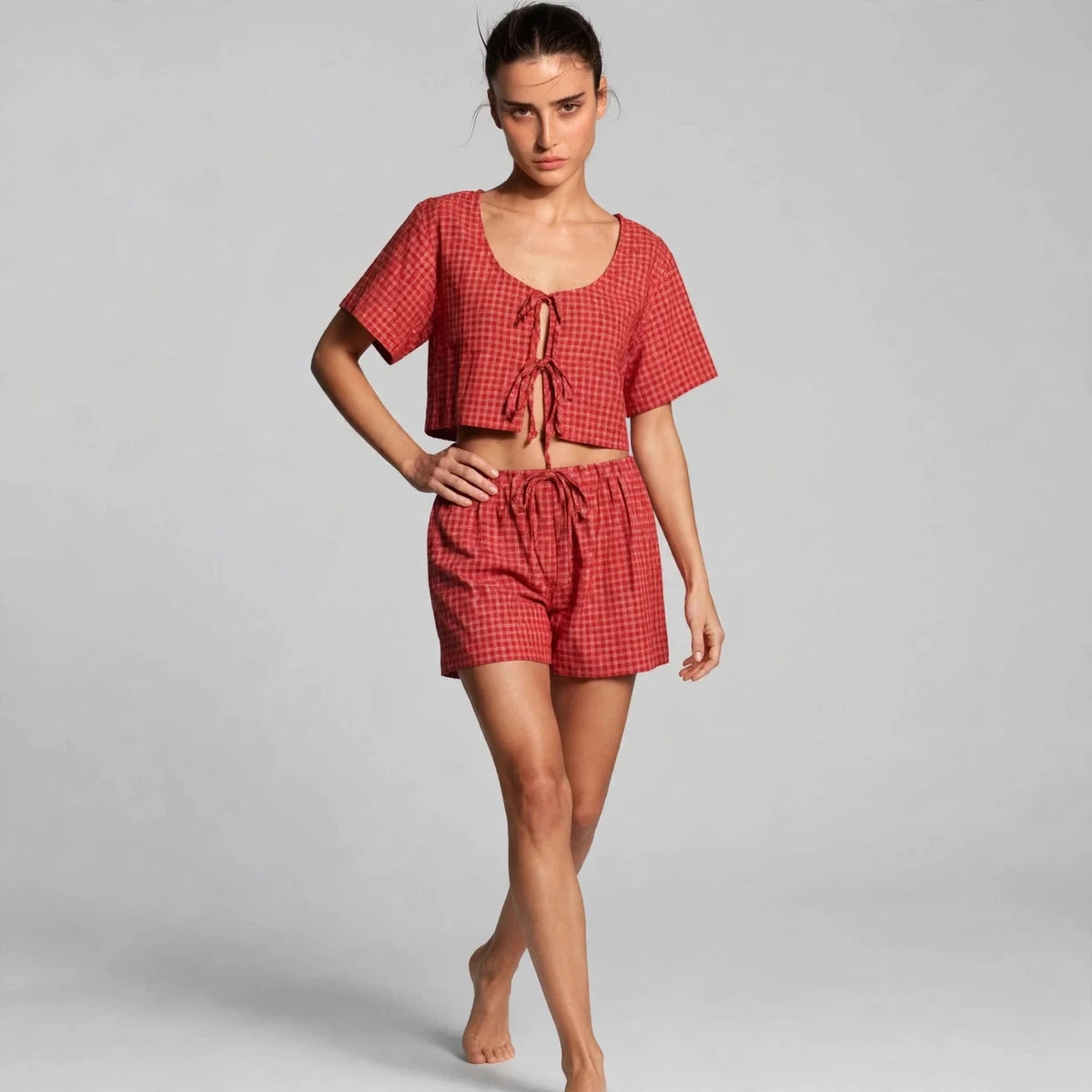 Model wearing deep red plaid tie-front set in a studio fashion pose