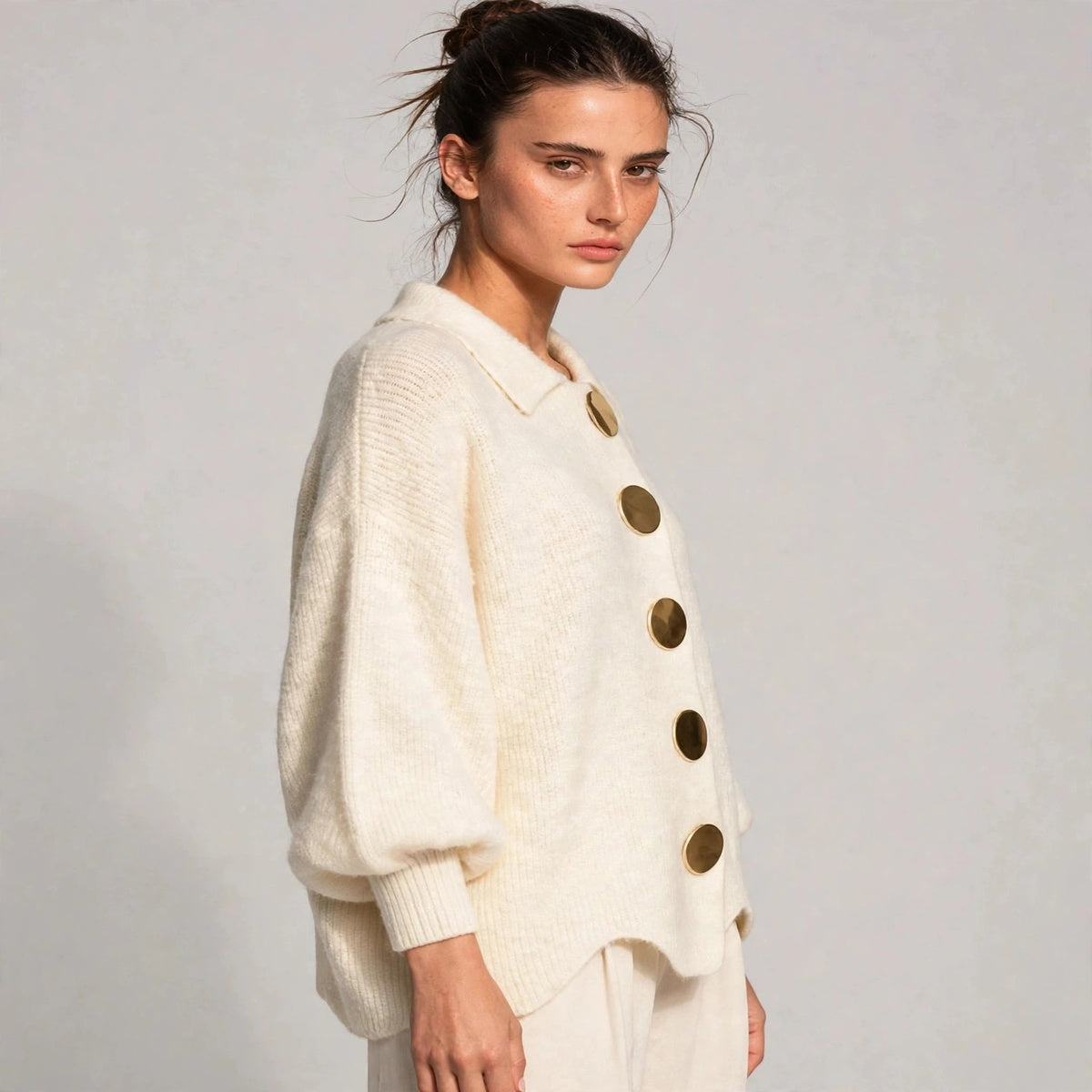 Side view of beige gold-button knit cardigan with lantern sleeves