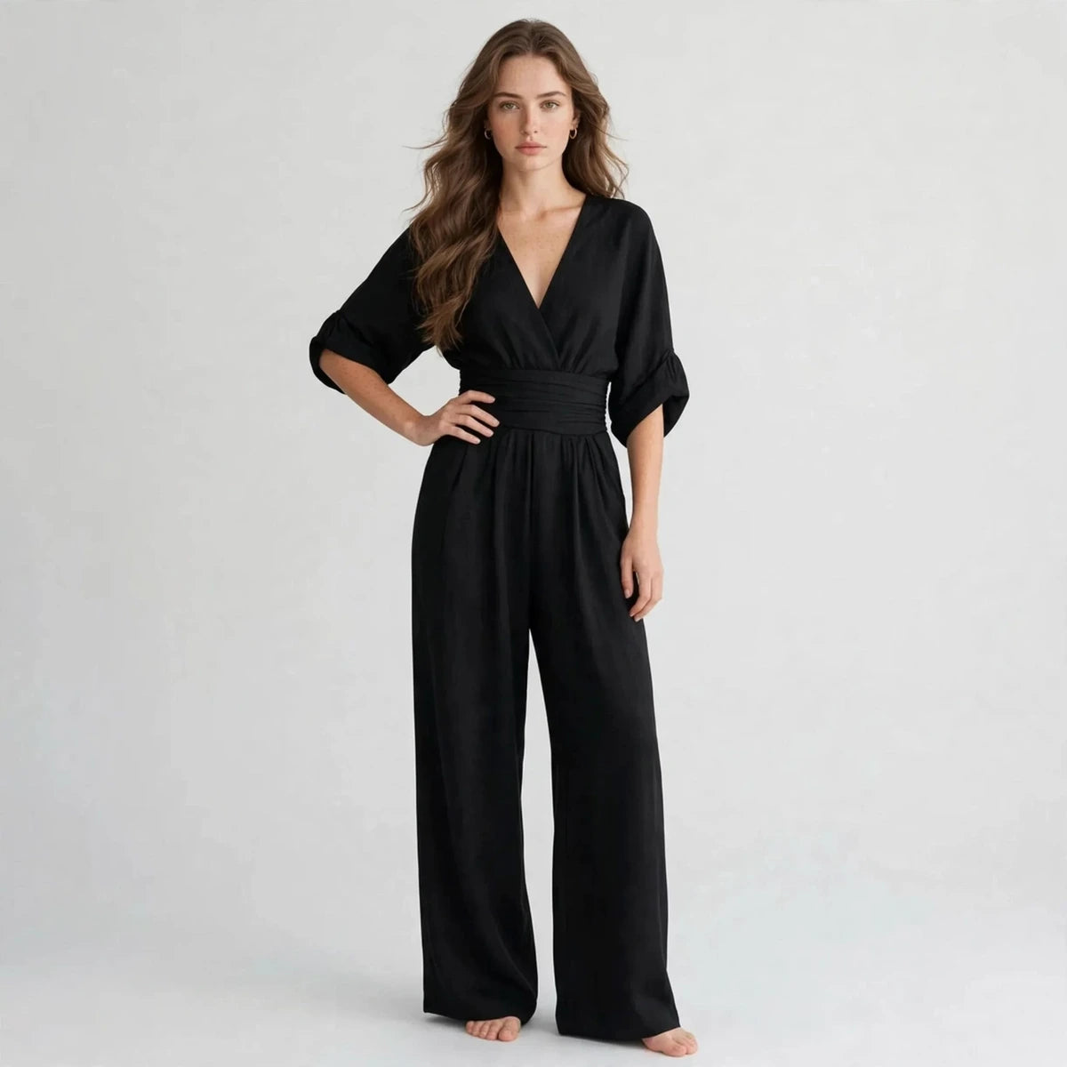 Woman wearing black half sleeve jumpsuit with v-neck wrap bodice
