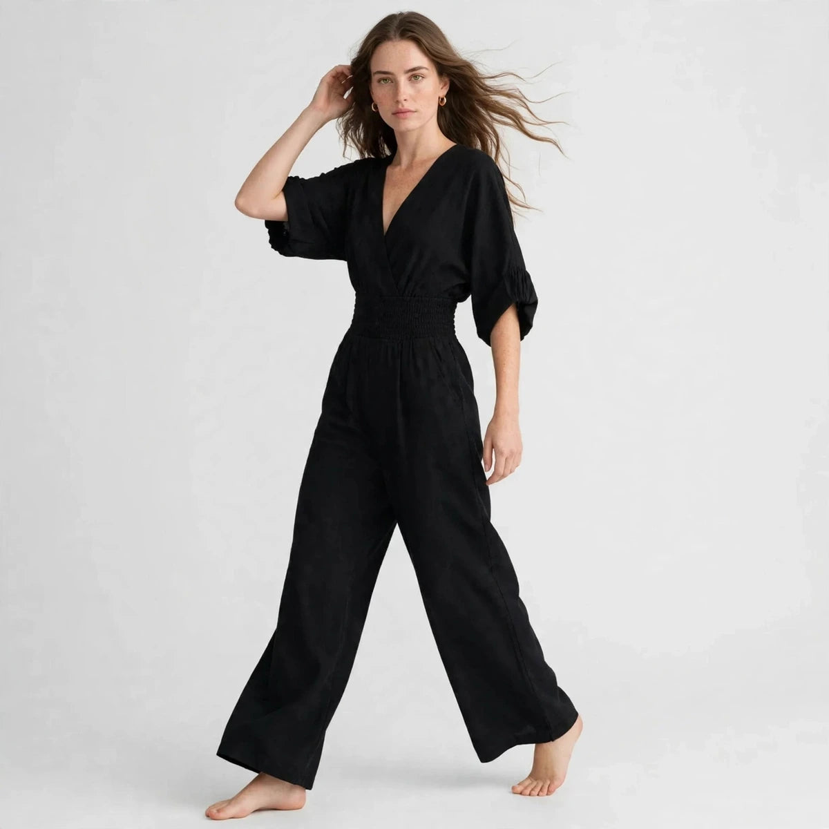 Black half sleeve jumpsuit with v-neckline, three-quarter view