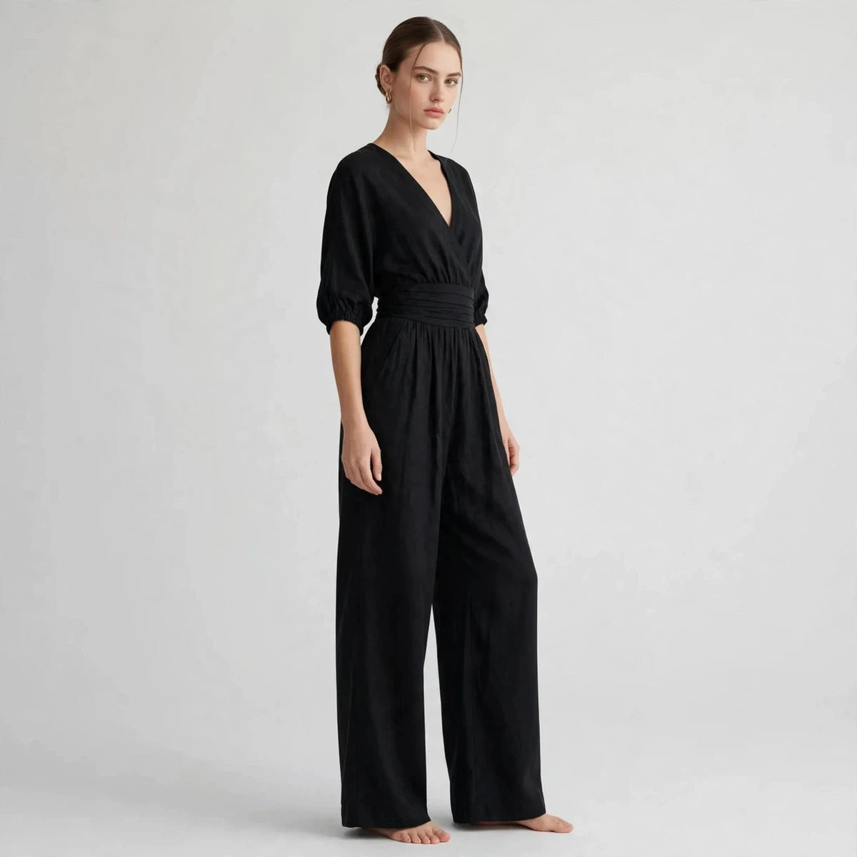 Side view of black half sleeve jumpsuit with smocked waist
