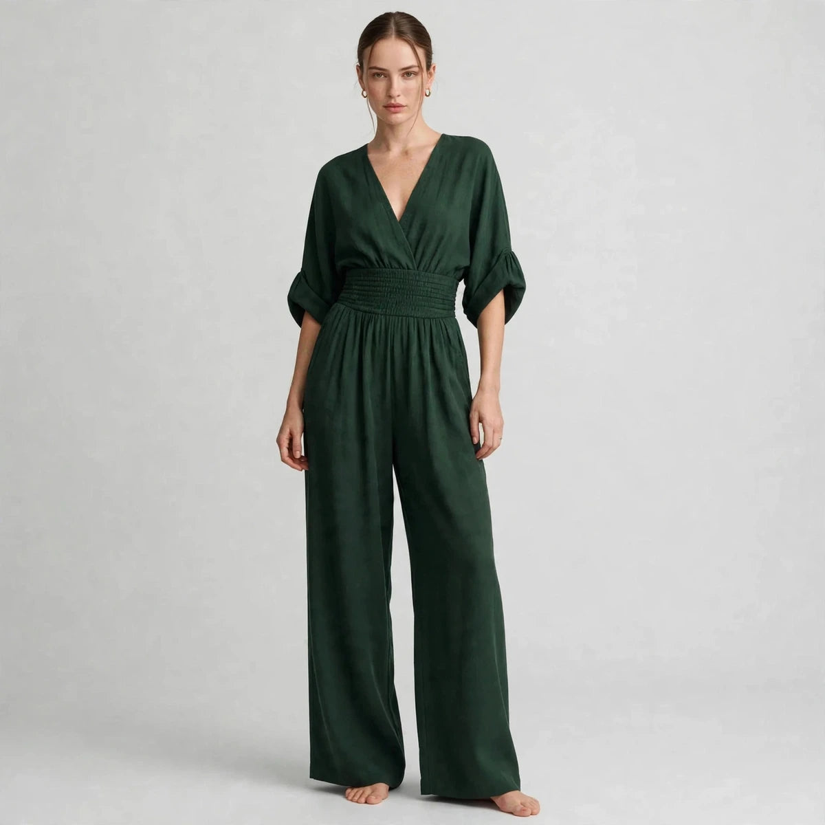 Model wearing dark green half sleeve jumpsuit in a fashion editorial