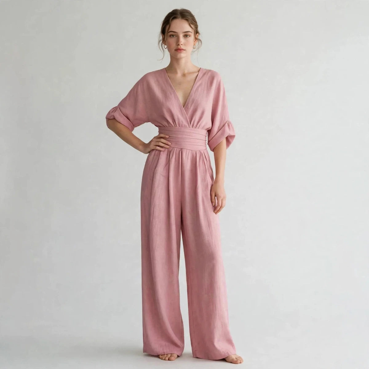 Woman wearing dusty pink half sleeve jumpsuit with v-neck bodice