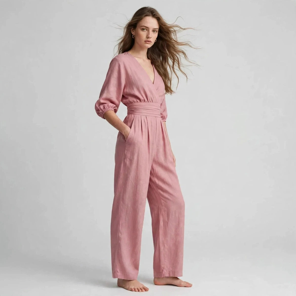 Dusty pink half sleeve jumpsuit, three-quarter view with flowing hair