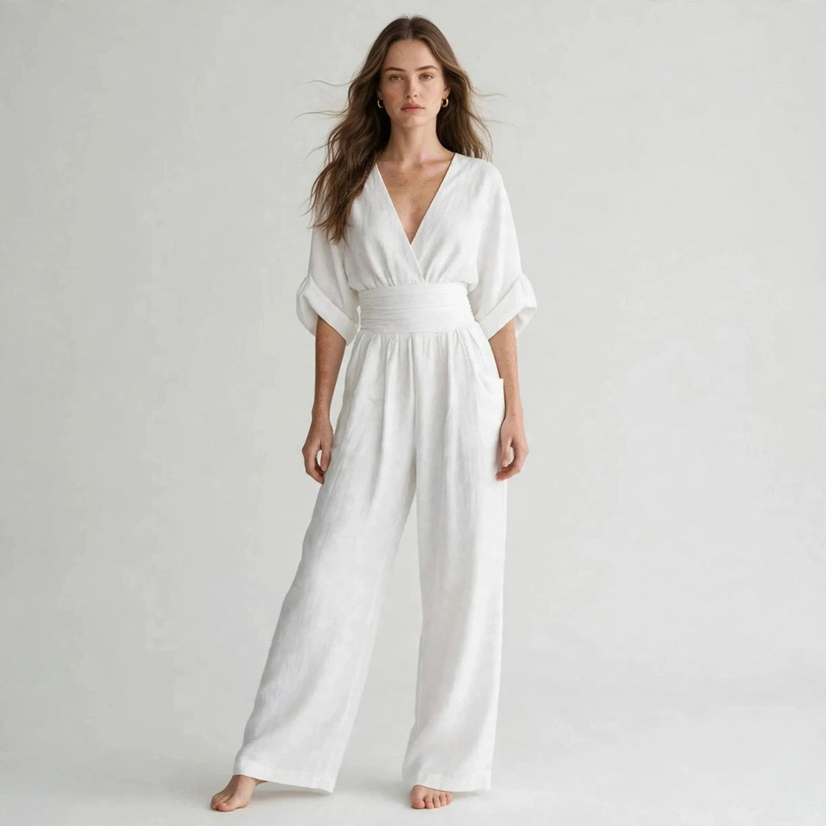 Woman wearing white half sleeve jumpsuit with v-neck wrap bodice