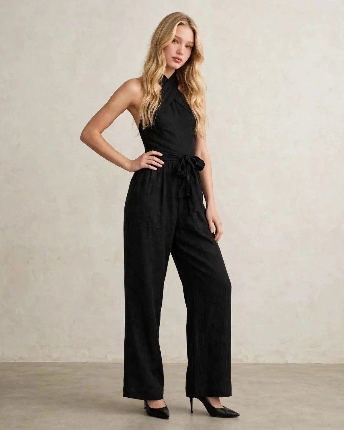 Women's halter neck wide-leg jumpsuit with waist tie in Black, side lean pose