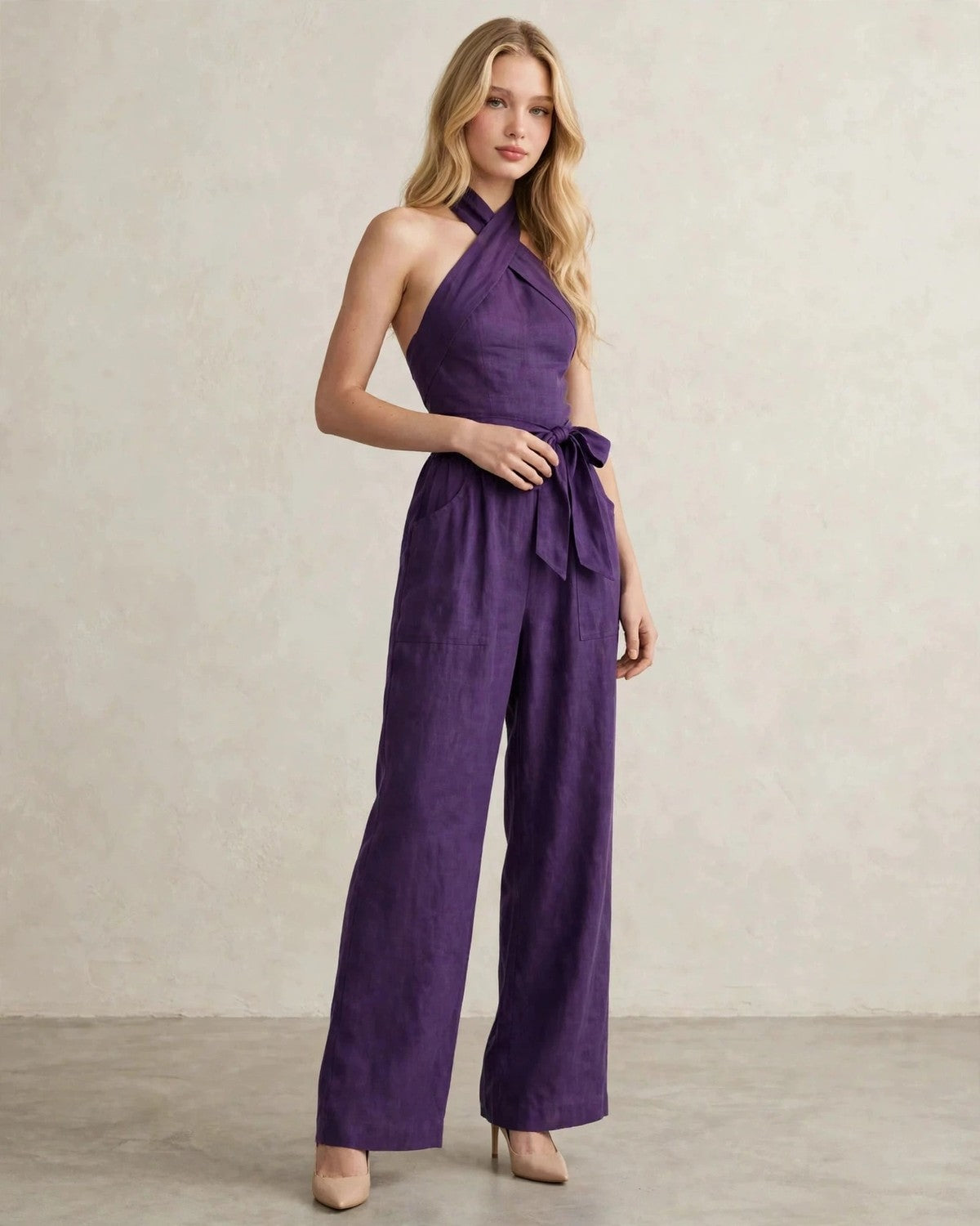 Women's halter neck wide-leg jumpsuit with waist tie in Purple, hand at waist pose