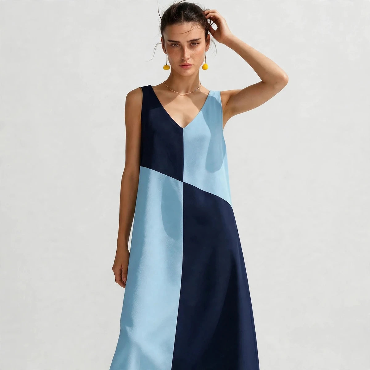 Three-quarter view of light blue and navy color-block V-neck maxi dress showing V neckline