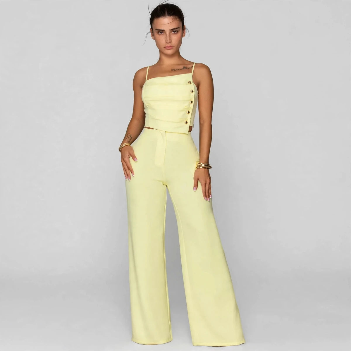 Woman wearing light yellow button cami top with wide-leg pants set, front view