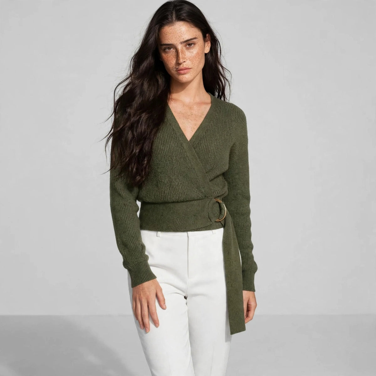 Women's army green metal ring wrap sweater, editorial pose, model in wrap knit sweater with gold ring waist tie