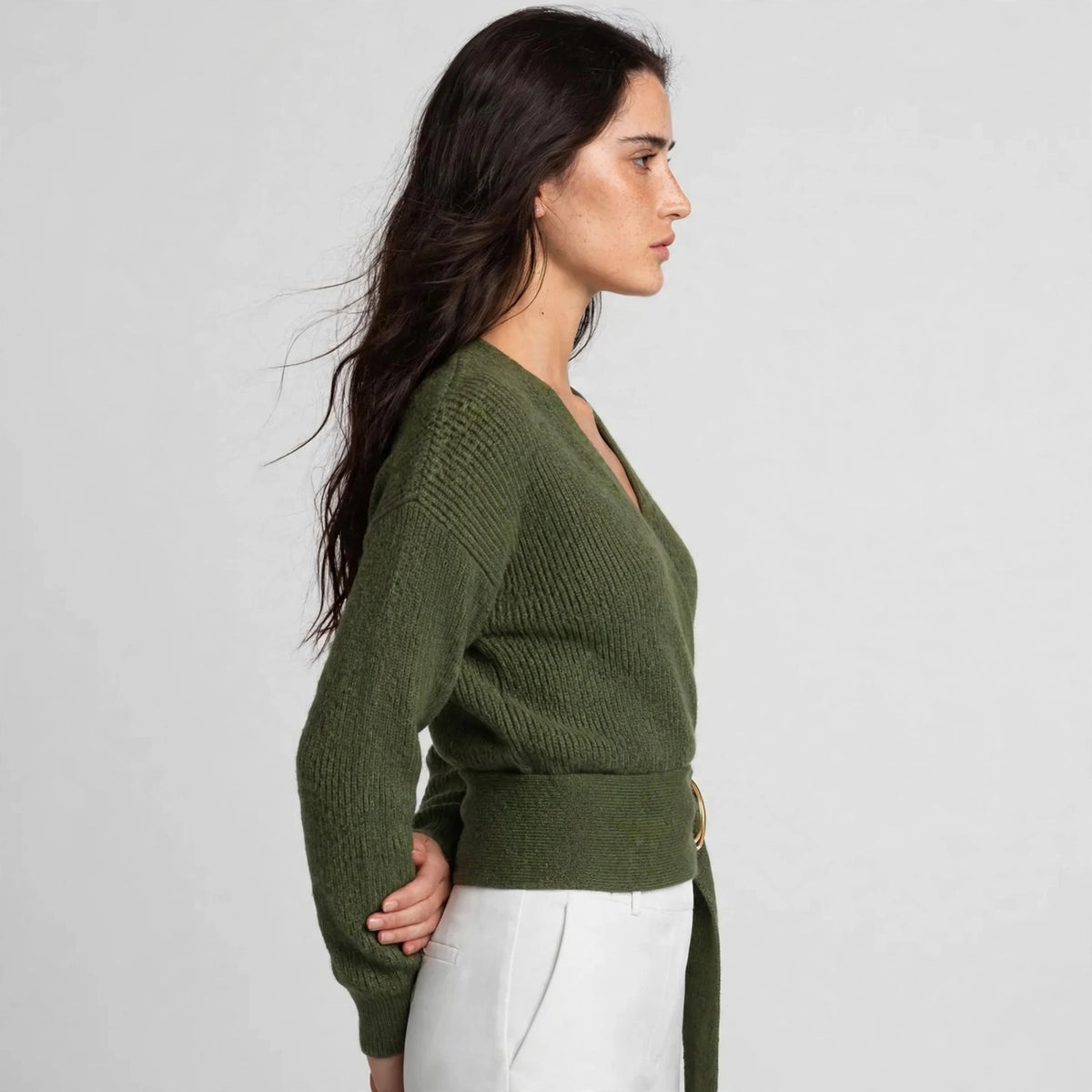 Side view of army green ring wrap sweater showing fitted silhouette and belt waist
