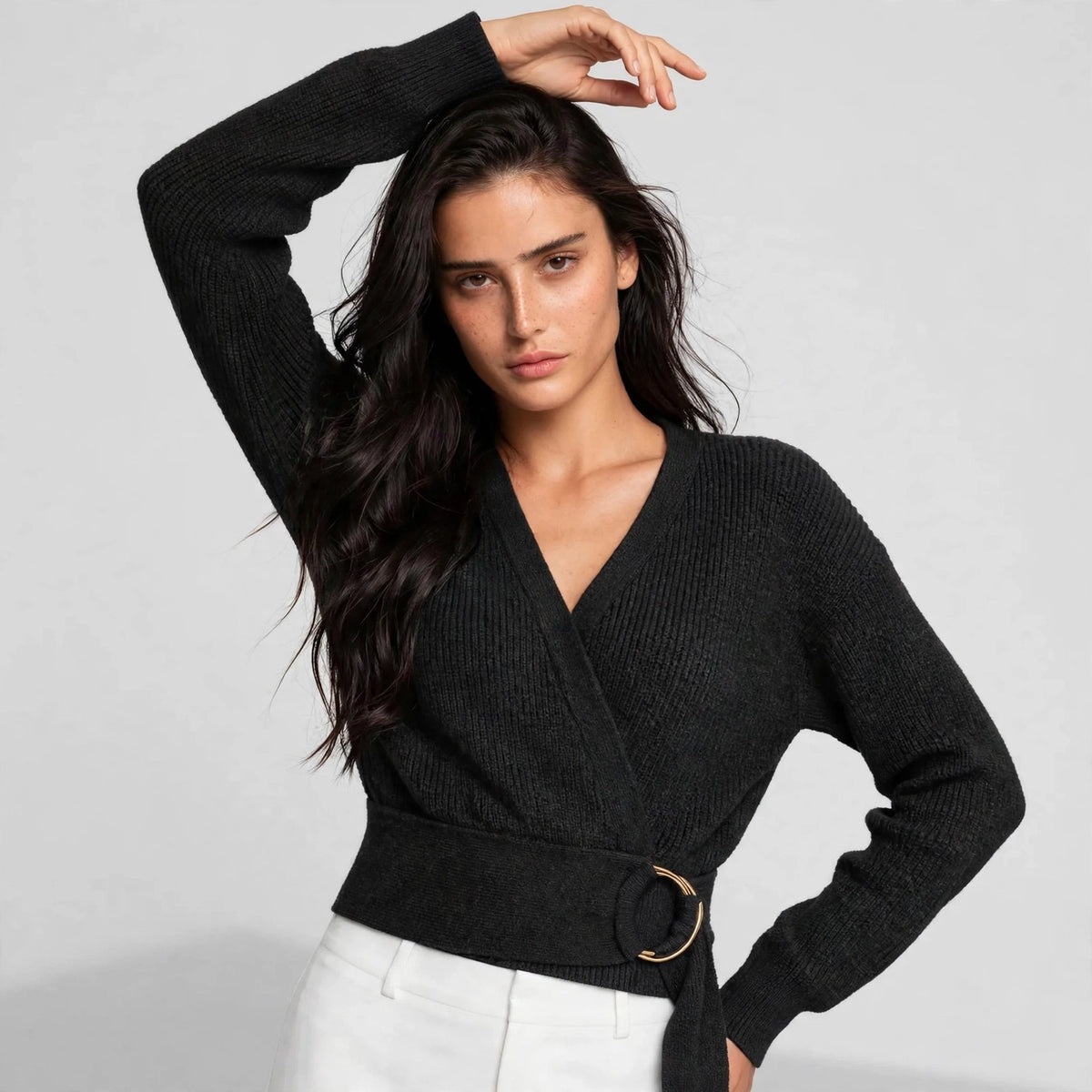 Styled pose showing black ring wrap sweater with ribbed knit texture