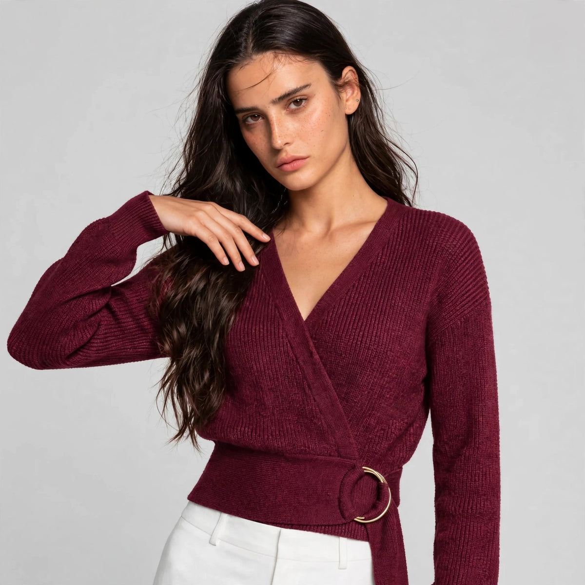 Woman wearing burgundy ring wrap sweater with wrap neckline and gold ring belt