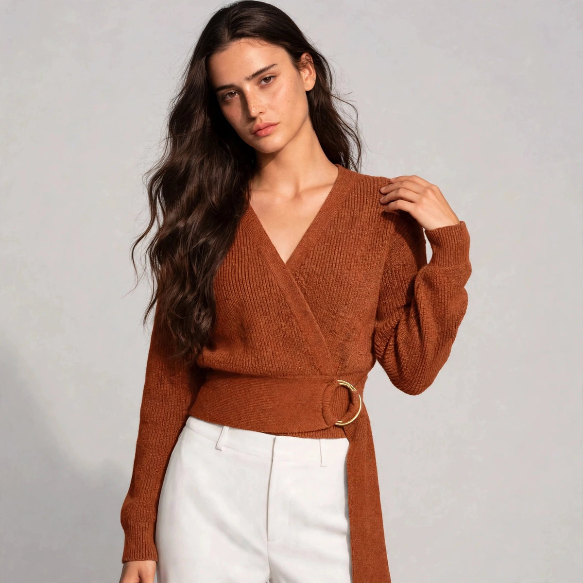 Woman wearing caramel ring wrap sweater with wrap neckline and gold ring belt
