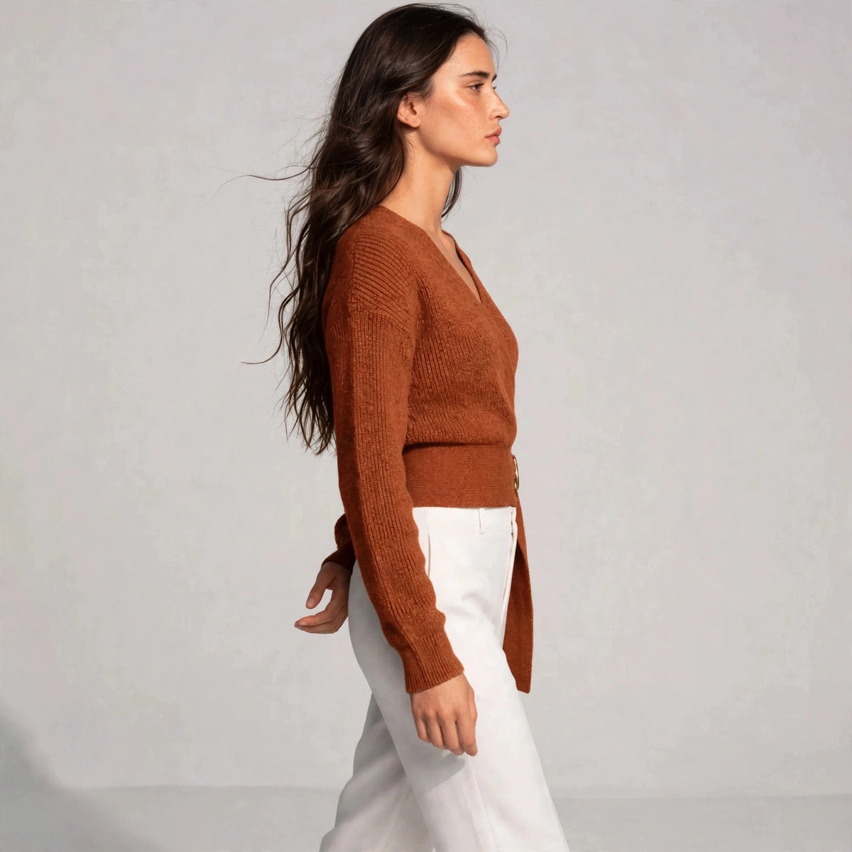 Side view of caramel ring wrap sweater showing fitted silhouette and belt waist