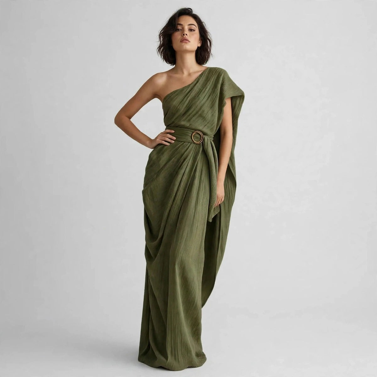 Model standing with hand on hip in an army green draped one-shoulder maxi dress with a belted ring buckle.